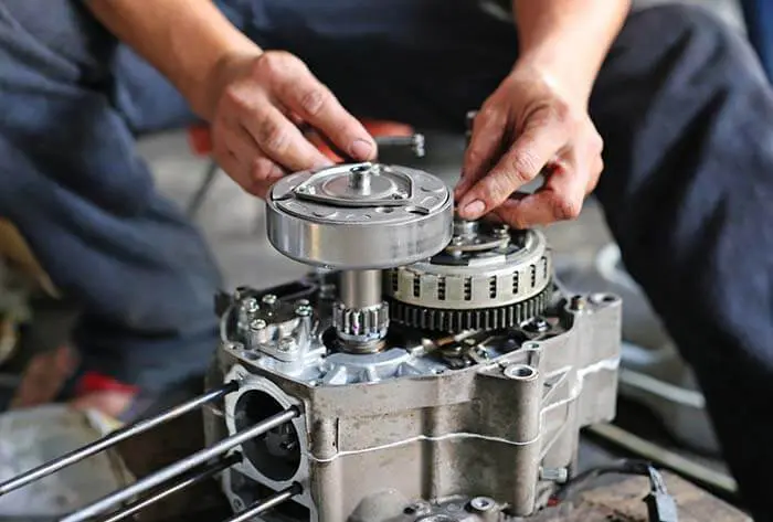 a pair of technician hand fixing the motorcycle